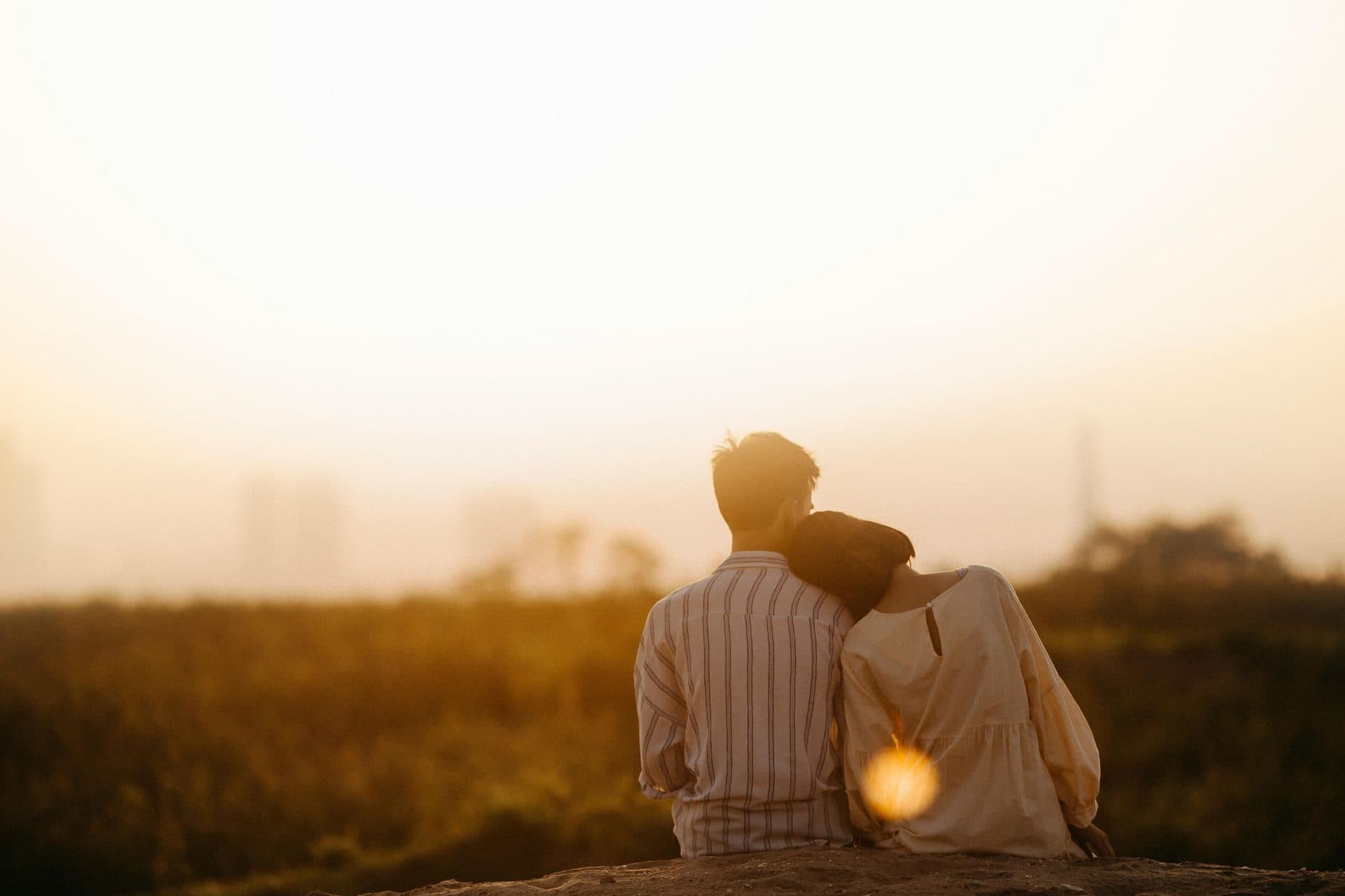 A couple sitting close together watching the sunset, representing reconnection through couples counseling